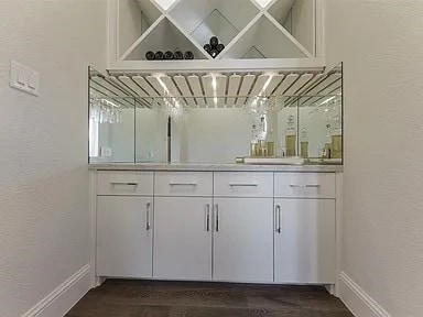 904 Devonshire Dr, Allen, TX 75013 - bar featuring baseboards, dark wood finished floors, and a textured wall