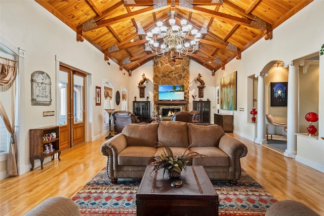 living room with wood ceiling, light wood finished floors, ornate columns, and a notable chandelier