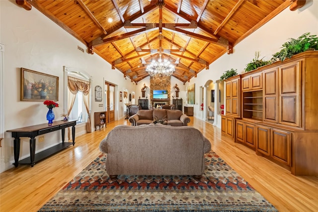 living area featuring wood ceiling, high vaulted ceiling, arched walkways, and light wood-style flooring