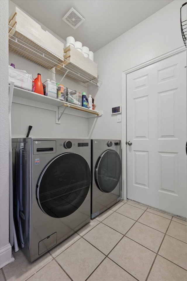 8926 White Pine Ln, Dallas, TX 75238 - laundry area with washer and dryer, light tile patterned flooring, laundry area, and visible vents