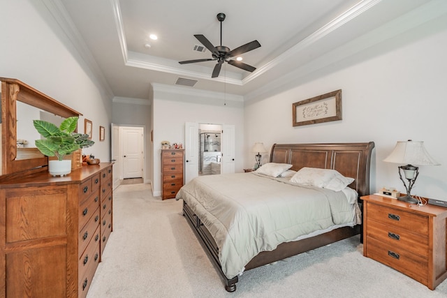 bedroom with visible vents, crown molding, light colored carpet, a raised ceiling, and a ceiling fan