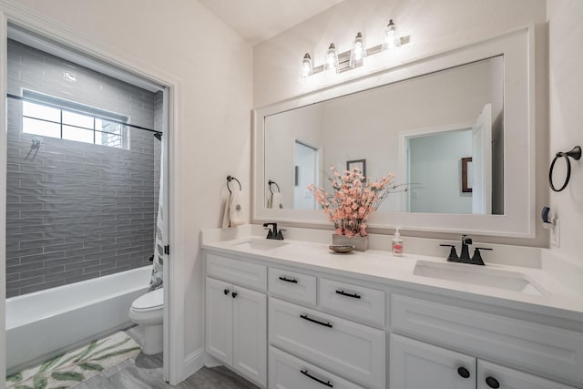bathroom featuring double vanity, toilet, shower / bath combination with curtain, and a sink
