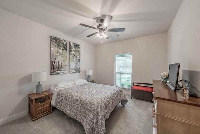 carpeted bedroom featuring baseboards, a ceiling fan, and visible vents