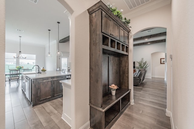 mudroom with visible vents, arched walkways, light wood-style flooring, and crown molding