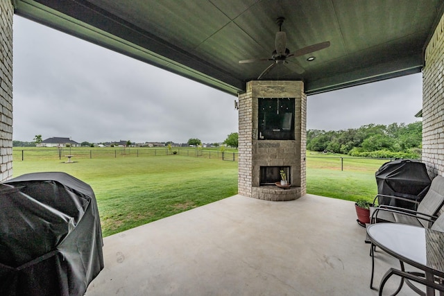 view of patio / terrace featuring a ceiling fan, fence, grilling area, and an outdoor brick fireplace