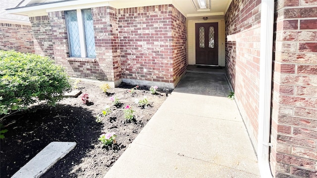 view of exterior entry with brick siding