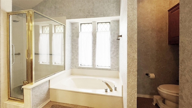 bathroom with baseboards, a bath, toilet, and a shower stall