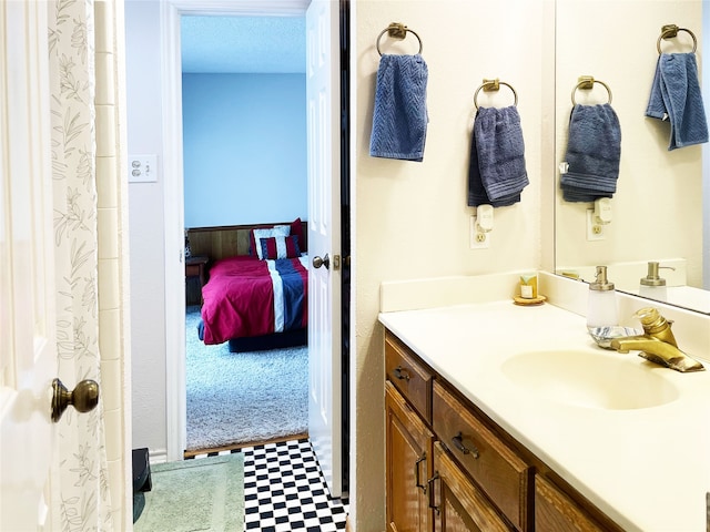 ensuite bathroom featuring vanity, ensuite bath, and tile patterned floors