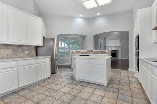 kitchen with appliances with stainless steel finishes, tasteful backsplash, light countertops, baseboards, and white cabinetry