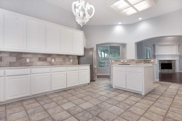 kitchen with decorative backsplash, light countertops, freestanding refrigerator, open floor plan, and recessed lighting