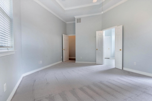 unfurnished bedroom with visible vents, baseboards, a towering ceiling, and carpet floors