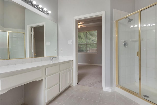 bathroom with ceiling fan, a stall shower, vanity, tile patterned floors, and baseboards