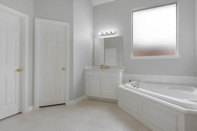 full bath with tile patterned floors, a garden tub, and vanity