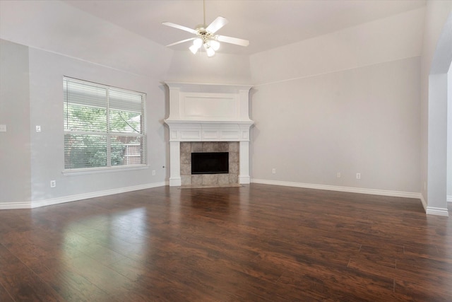 unfurnished living room with dark wood-style flooring, baseboards, ceiling fan, high vaulted ceiling, and a tile fireplace