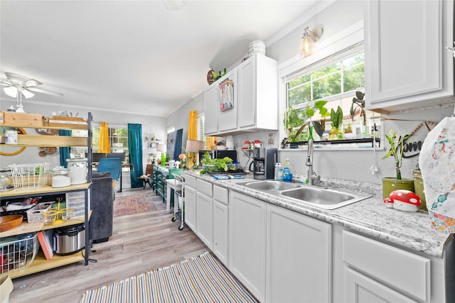 2612 1st St, Brownwood, TX 76801 - kitchen featuring a sink, white cabinets, light countertops, and light wood-style floors