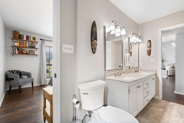 4145 Malone Ave, The Colony, TX 75056 - full bathroom featuring double vanity, a sink, wood finished floors, and toilet