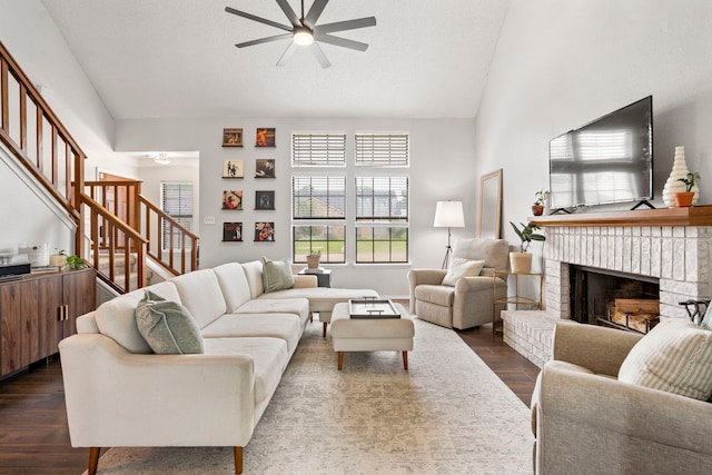 4145 Malone Ave, The Colony, TX 75056 - living room featuring stairs, a fireplace, dark wood-style floors, high vaulted ceiling, and a ceiling fan