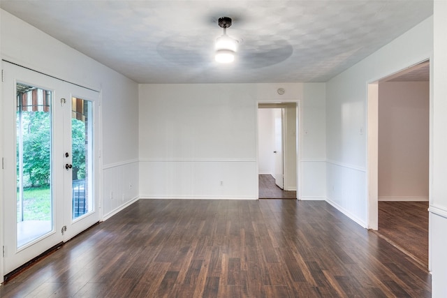 empty room featuring a healthy amount of sunlight, baseboards, ceiling fan, and dark wood-style flooring
