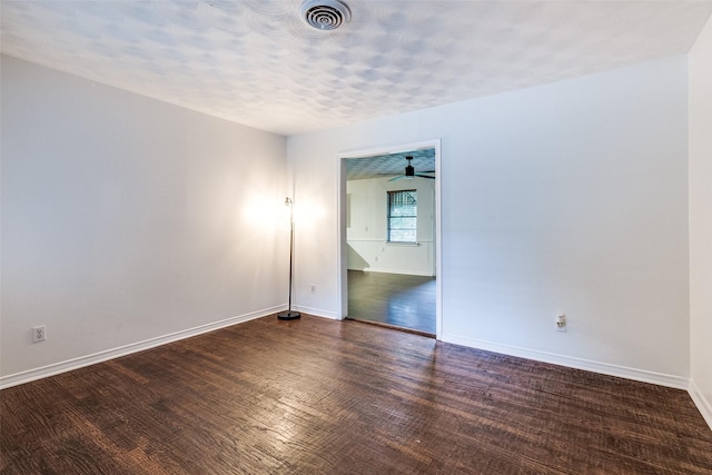 empty room with visible vents, a ceiling fan, baseboards, and wood finished floors