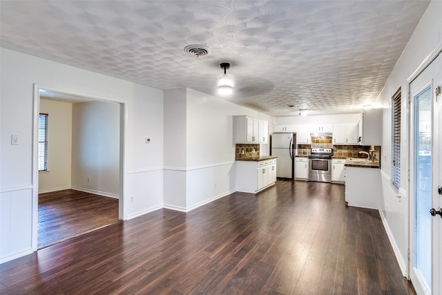 unfurnished living room featuring baseboards, dark wood finished floors, and visible vents