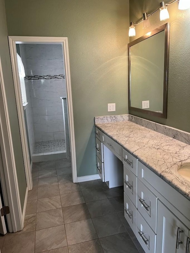1824 Shady Point Circle Dr, San Angelo, TX 76904 - full bathroom with vanity, baseboards, a tile shower, and a textured wall