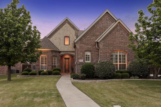 1306 Andrew Ct, Lewisville, TX 75056 - french provincial home featuring brick siding, a front lawn, stone siding, and central AC