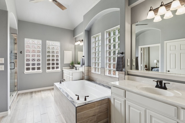 1306 Andrew Ct, Lewisville, TX 75056 - bathroom with ceiling fan, two vanities, a garden tub, healthy amount of natural light, and lofted ceiling