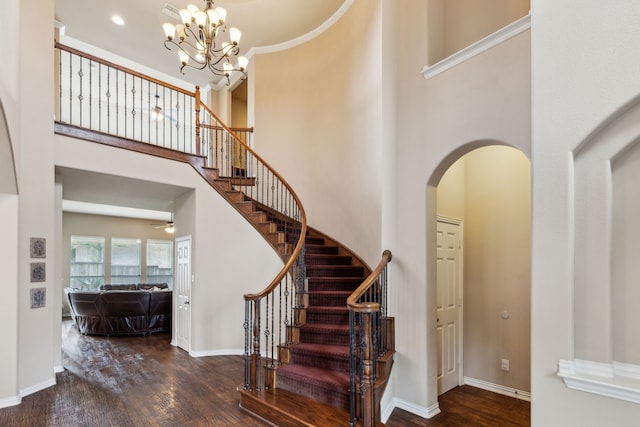 1306 Andrew Ct, Lewisville, TX 75056 - foyer entrance featuring a towering ceiling, arched walkways, wood finished floors, stairs, and baseboards