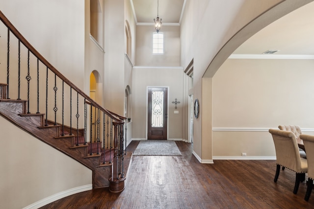 1306 Andrew Ct, Lewisville, TX 75056 - entryway featuring wood finished floors, arched walkways, stairs, a towering ceiling, and baseboards