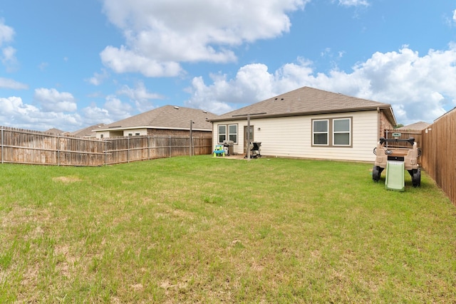 back of property featuring a lawn and a fenced backyard