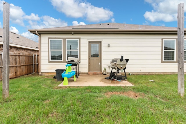 rear view of house with a patio area, fence, and a yard