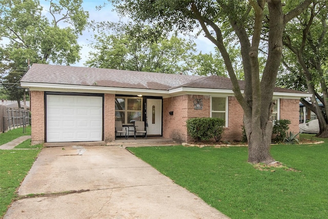 ranch-style house with fence, a front yard, brick siding, an attached garage, and driveway