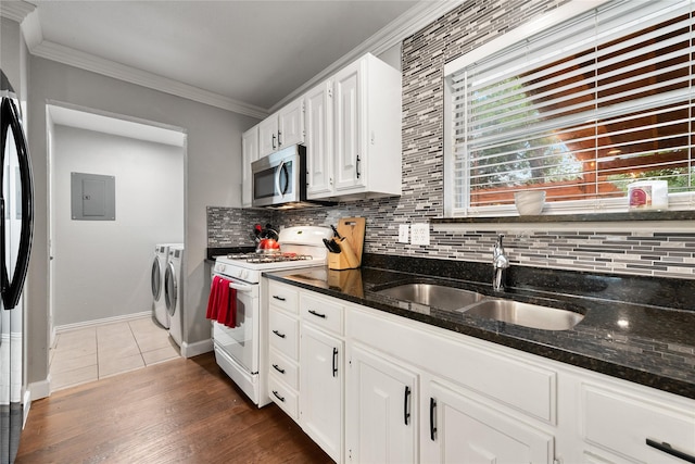 kitchen featuring ornamental molding, washer and clothes dryer, white range with gas cooktop, stainless steel microwave, and a sink