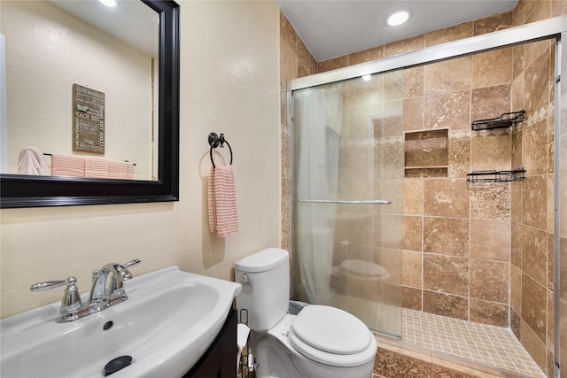 bathroom featuring vanity, recessed lighting, a stall shower, and toilet