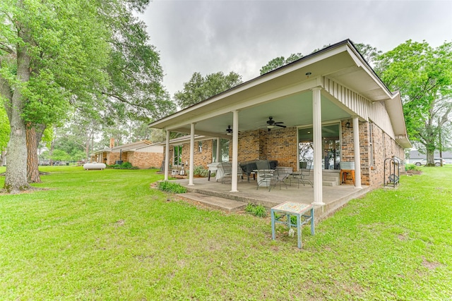 back of house featuring a yard, brick siding, ceiling fan, and a patio