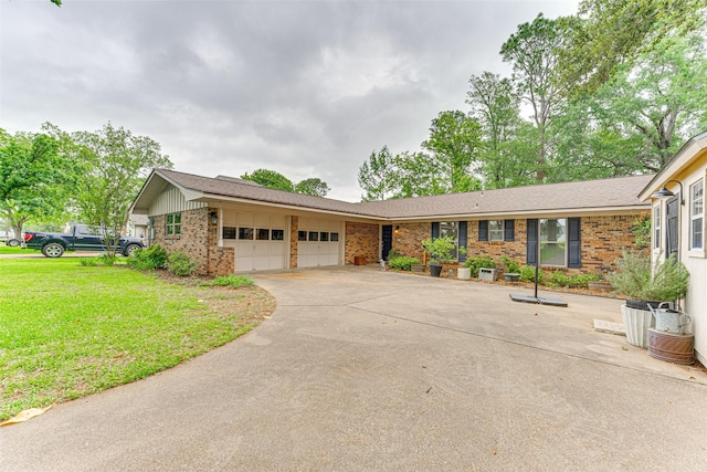 ranch-style home featuring concrete driveway, an attached garage, a front yard, and brick siding