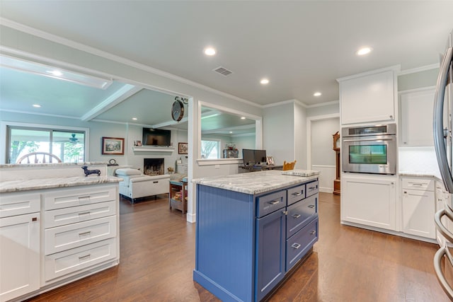kitchen featuring plenty of natural light, white cabinets, dark wood-style flooring, and oven