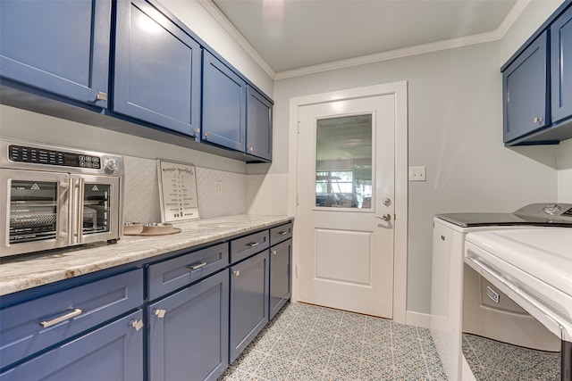 laundry room featuring cabinet space, baseboards, a toaster, ornamental molding, and washer and clothes dryer