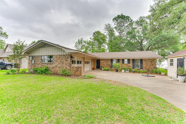 single story home featuring brick siding, a front lawn, an attached garage, and concrete driveway