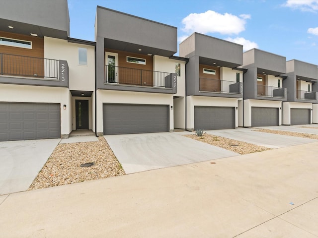 view of front of home with an attached garage, driveway, and stucco siding
