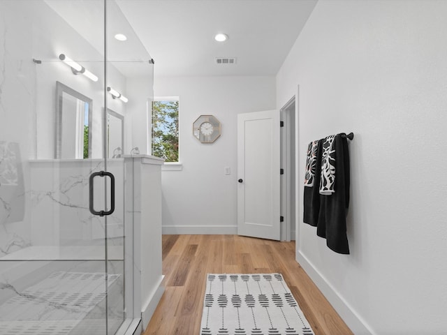 bathroom with a marble finish shower, recessed lighting, baseboards, wood finished floors, and visible vents