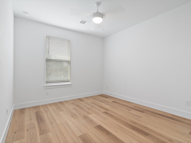 empty room with ceiling fan, visible vents, baseboards, and light wood finished floors