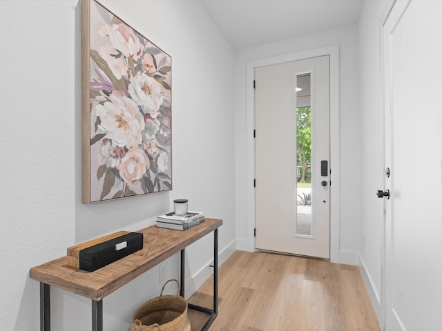 doorway featuring baseboards and light wood-style floors