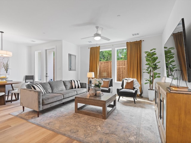 living area with visible vents, light wood-style flooring, and ceiling fan