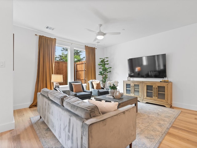 living area with baseboards, ceiling fan, visible vents, and light wood-style flooring