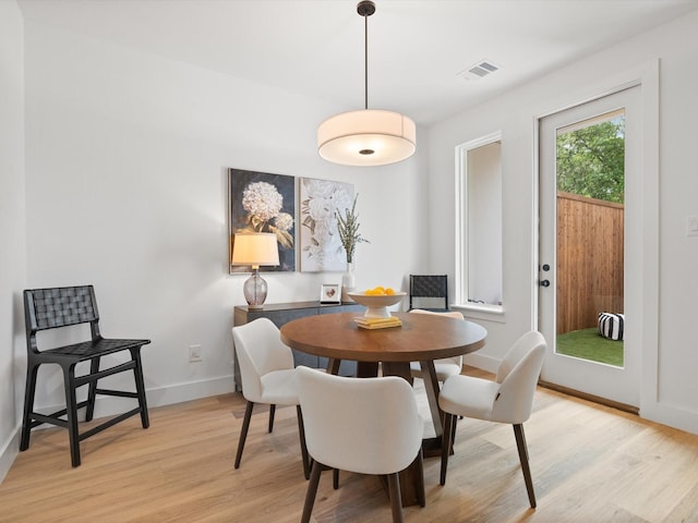 dining room featuring baseboards, light wood finished floors, and visible vents