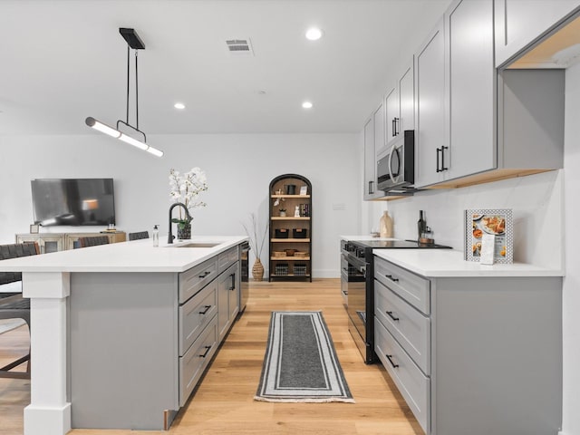 kitchen featuring a sink, gray cabinets, appliances with stainless steel finishes, and light wood finished floors