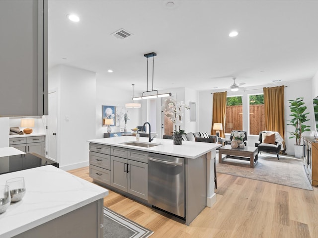kitchen featuring visible vents, gray cabinets, a sink, light wood finished floors, and dishwasher