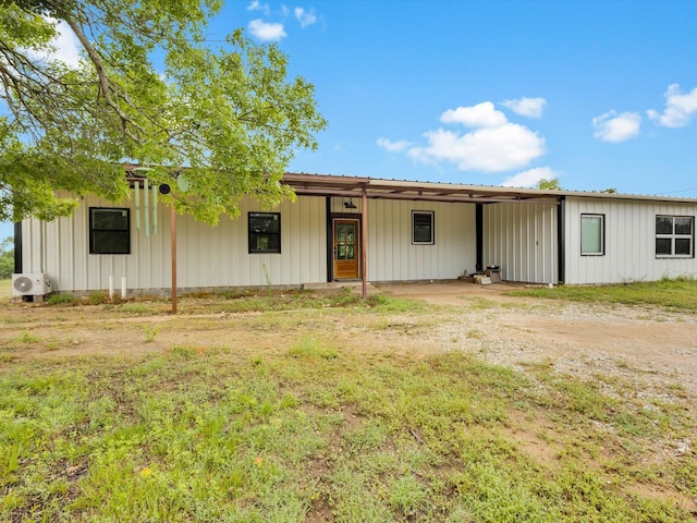 view of front of property featuring board and batten siding, metal roof, and a carport