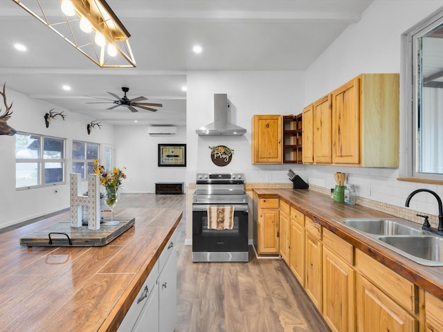 kitchen with stainless steel range with electric cooktop, wood counters, a sink, and wall chimney exhaust hood